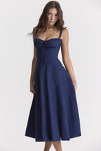 Load image into Gallery viewer, A model showcases a navy blue corset midi dress with a plait front, sleeveless design, and two shoulder straps, crafted from light, breathable fabric for a comfortable yet elegant look.
