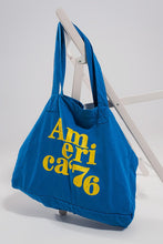 Load image into Gallery viewer, This America 76 Canvas Tote is a durable cotton canvas tote that has been made with a plain design and yellow text over the front. It has two urban twin handles, which help to give this bag a unique style. This bag is perfect for walking the dog, heading out to the beach with friends or going on a trip because of its durable design and open top concept. Made from durable 100% cotton canvas, and featuring an open top concept for convenient access, this roomy bag is ideal for everyday use.