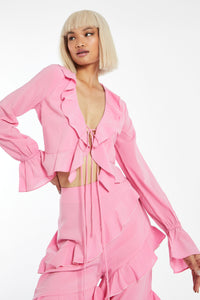 From the Glam Expressway Boutique collection of fun, flirty, and stylish women's clothes, comes this Blush Pink Ruffle Blouse that is sweet, pretty and on trend. This top has two self tie bows in the front and ruffle details at the sleeve. Wear this top with the matching pants sold separately or wear it with jeans. This blouse is perfect for any summer outing!