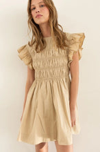 Load image into Gallery viewer, Model wearing a lightweight cotton babydoll mini dress with smocked bodice, ruffled sleeves, and a flowy skirt—perfect for staying cool in summer. The dress features hidden side pockets and a relaxed fit, ideal for casual outings, beach vacations, or warm-weather brunches.
