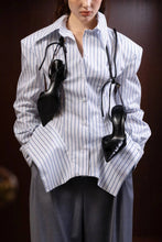 Load image into Gallery viewer, Model wearing a blue-and-white pinstripe peplum blouse with dramatic puffed sleeves, pointed collar, front buttons, and flared hem.
