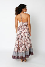 Load image into Gallery viewer, Our beautiful boho chic maxi dress is a statement piece for any occasion. This perfect summer dress features an open back, halter neck, side cut outs and a gorgeous maxi length. A feminine frill at the hem adds the perfect touch. This maxi dress will be a summer staple in your closet. The Cut Out Halter Maxi Dress has neutral tones and is made from 100% organic cotton. Wear it to parties, weddings, brunches...you name it.
