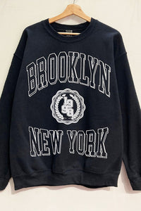 Elevate your style with our Long Sleeve Crew-Neck "Brooklyn New York" Varsity Oversized Graphic Sweatshirt. Embrace comfort and sophistication in this chic black sweater featuring the iconic "Brooklyn" in bold white lettering on the front. Crafted for a soft touch, this sweatshirt seamlessly combines fashion and comfort, making it a must-have for any wardrobe. Embody the spirit of Brooklyn with this versatile piece that blends street style with urban elegance.