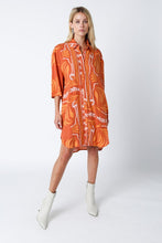 Load image into Gallery viewer, Light and breezy, this versatile shirt dress features a gorgeous orange and cream print, 3/4 sleeves and a button closure at the front. Perfect for running errands or vacation days at the beach. This versatile and chic shirt dress can be worn as a dress, a swimsuit cover up or a top. The styling possibilities are endless. 
