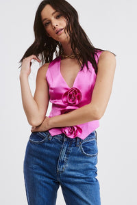 Introducing our Pink Rosette Satin Vest Top - Our take on a Y2K-inspired vest. Crafted from a solid satin fabric with exquisite rosette bud detailing on the front, it adds a trendy twist to a classic style. The V neckline, pointed front hem, and cropped fit embrace the perfect blend of contemporary and timeless charm. Pair this charming vest with denim or trousers to complete the look! Model is wearing a size Small. Dress it up or  down!