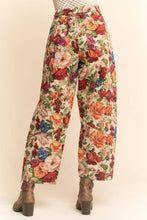 Load image into Gallery viewer, Floral tapestry cargo jogger pants with a high-rise fit, relaxed silhouette, and multicolor vintage-inspired print, styled with ankle boots.
