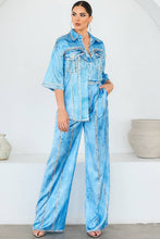 Load image into Gallery viewer, Woman wearing a light blue denim looking satin outfit against a white background
