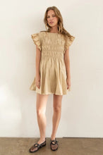 Load image into Gallery viewer, Model wearing a lightweight cotton babydoll mini dress with smocked bodice, ruffled sleeves, and a flowy skirt—perfect for staying cool in summer. The dress features hidden side pockets and a relaxed fit, ideal for casual outings, beach vacations, or warm-weather brunches.
