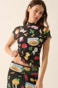 Model wearing the colorful Italian food print mesh set from Glam Expressway, featuring a fitted long sleeve crop top and a high-waisted foldover waistband maxi skirt with pasta, pizza, and tomato motifs — perfect for bold, statement resort wear or summer styling.