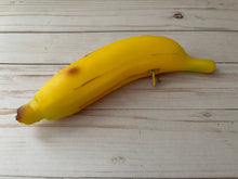 Load image into Gallery viewer, Realistic banana-shaped coin purse with zipper, keychain ring, and bag charm attachment displayed on a wood background.
