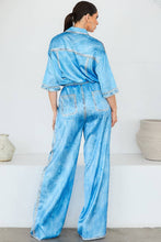 Load image into Gallery viewer, Woman wearing a light blue denim effect satin outfit with a white background
