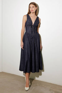 Turn heads in this elegant Solid Denim Corset Midi Dress! Featuring a deep V-neckline and sleeveless design, this dress is all about understated sophistication. The front tie detail and contouring waist accentuate your shape, while the flowing full skirt adds a touch of timeless charm. Perfect for dates, brunches, or evenings out, this versatile midi dress is a must-have for your wardrobe!