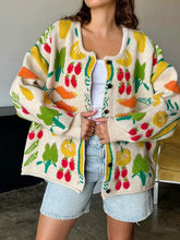 Load image into Gallery viewer, Brighten up any day with our Fruity Knit Cardigan Sweater! This cozy piece features an oversized fit for easy layering, complete with long sleeves and a ribbed hem for that perfect slouchy look. Crafted from a soft, medium-weight jacquard knit, it’s adorned with a playful multi-colored fruit pattern that’s sure to lift your spirits. With a button-up front and hip-length cut, this cardigan is designed for effortless style and comfort—One size truly fits most!
