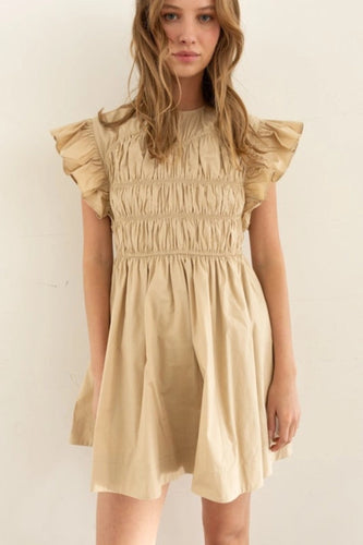 Model wearing a lightweight cotton babydoll mini dress with smocked bodice, ruffled sleeves, and a flowy skirt—perfect for staying cool in summer. The dress features hidden side pockets and a relaxed fit, ideal for casual outings, beach vacations, or warm-weather brunches.