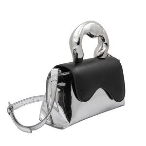 Meet our Silver and Black Top Handle Bag, one of the most unique and intricate handbags you will find. Made out of recycled vegan leather this metallic top handle bag makes a fashionable yet sustainable statement piece. Wear it comfortably as a crossbody bag using the adjustable strap for hands-free convenience. 