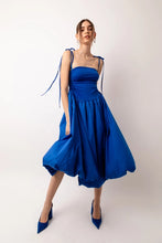 Load image into Gallery viewer, A stunning strapless midi dress with stretch fitted bodice and a full cotton skirt. Drawstring tie details either side of the bodice to create a slight ruched effect. The skirt is fully lined and has a classic puff ball effect. Dress it up or down! 
