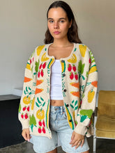 Load image into Gallery viewer, Brighten up any day with our Fruity Knit Cardigan Sweater! This cozy piece features an oversized fit for easy layering, complete with long sleeves and a ribbed hem for that perfect slouchy look. Crafted from a soft, medium-weight jacquard knit, it’s adorned with a playful multi-colored fruit pattern that’s sure to lift your spirits. With a button-up front and hip-length cut, this cardigan is designed for effortless style and comfort—One size truly fits most!
