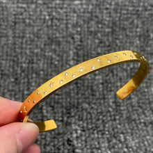 Load image into Gallery viewer, 18K gold-plated open cuff bracelet with scattered clear cubic zirconia stones and delicate engraved starburst details.
