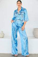 Load image into Gallery viewer, Woman wearing a light blue denim printed shirt and pants set against a white background
