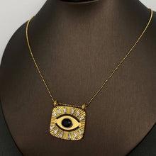 Load image into Gallery viewer, 18K gold-plated All Seeing Eye pendant necklace featuring a black center stone, clear zircon accents and textured sunburst design.
