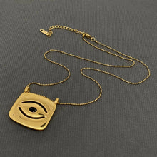 Load image into Gallery viewer, 18K gold-plated All Seeing Eye pendant necklace featuring a black center stone, clear zircon accents and textured sunburst design.
