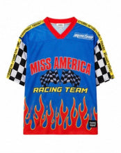 Load image into Gallery viewer, Woman wearing the All American Racing Team oversized mesh jersey featuring blue racing graphics, checkered sleeves, flame details, varsity lettering, and a large number 76 on the back.

