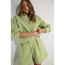 Load image into Gallery viewer, Apple green embossed lounge shorts with relaxed fit and textured fabric styled as part of a matching set.
