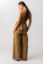Load image into Gallery viewer, Woman wearing a brown peblum top and wide leg pants on a white background
