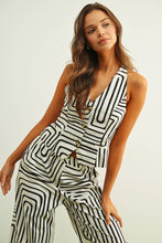 Load image into Gallery viewer, Black and cream abstract print tailored vest top with halter neckline and button front styled as a matching set.

