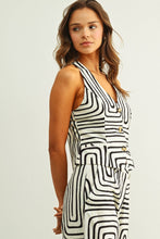 Load image into Gallery viewer, Black and cream abstract print tailored vest top with halter neckline and button front styled as a matching set.
