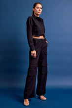 Load image into Gallery viewer, Structured black cropped cargo jacket with stretch and utility pockets. A polished, fashion-forward layer. Matching cargo pants sold separately.
