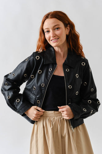 Woman wearing a Glam Expressway black & silver leather jacket with eyelets on a white background
