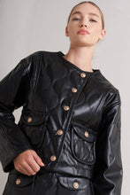 Load image into Gallery viewer, Person wearing a Glam Expressway black leather jacket with gold buttons on a plain background
