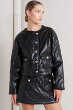 Load image into Gallery viewer, Glam Expressway Black leather jacket with gold buttons worn by a model on a plain background

