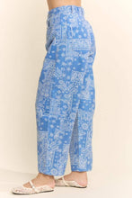 Load image into Gallery viewer, Blue wide-leg cotton pants featuring an allover white paisley bandana print, high-rise waist, relaxed fit, and cropped wide-leg silhouette styled with white lace flats.

