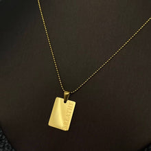 Load image into Gallery viewer, 18K gold-plated rectangular pendant necklace engraved with the word “BREATHE” on a delicate gold chain.
