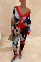 Load image into Gallery viewer, Person wearing a colorful outfit with a patterned cardigan and pants on a beige background
