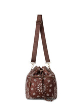 Load image into Gallery viewer, Walnut brown bandana print convertible bucket bag with drawstring closure and adjustable straps that can be worn as a backpack, shoulder bag, or crossbody bag.

