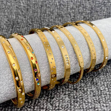 Load image into Gallery viewer, 18K gold-plated stainless steel cuff bracelet with engraved celestial starbursts and sparkling cubic zirconia accents.
