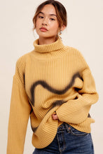 Load image into Gallery viewer, Woman wearing a mustard yellow sweater with a black abstract design on a beige background
