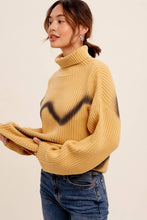 Load image into Gallery viewer, Woman wearing a mustard yellow sweater with black paint splashes on a beige background
