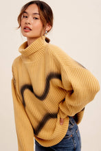 Load image into Gallery viewer, Woman wearing a mustard yellow sweater with black abstract design on a beige background
