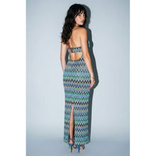 Load image into Gallery viewer, Model wearing a fitted blue and green chevron print halter maxi dress featuring a plunging front cutout, ring hardware detail, and body-skimming silhouette.
