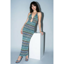 Load image into Gallery viewer, Model wearing a fitted blue and green chevron print halter maxi dress featuring a plunging front cutout, ring hardware detail, and body-skimming silhouette.
