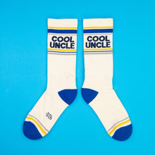 Load image into Gallery viewer, Cream crew socks with blue heel and toe featuring “Cool Uncle” text and striped accents.
