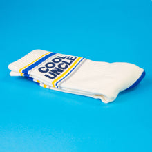Load image into Gallery viewer, White socks with blue and yellow accents and 'Cool Uncle' text on a blue background
