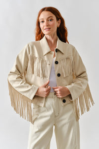 Woman wearing a beige fringed jacket on a white background