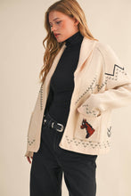 Load image into Gallery viewer, Woman wearing a cream-colored cardigan with patterned design on a beige background
