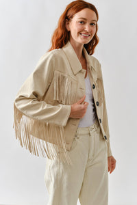 Woman wearing a beige fringed jacket on a white background