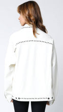 Load image into Gallery viewer, White vegan leather jacket with silver stud detailing, button-front closure, and front pockets, styled over a black top for a modern, edgy look.
